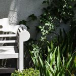 biała ławka w wiosennym ogrodzie